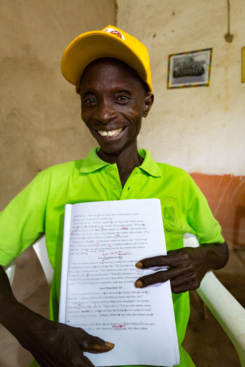 Man holding up hand-written Bible translation notes
